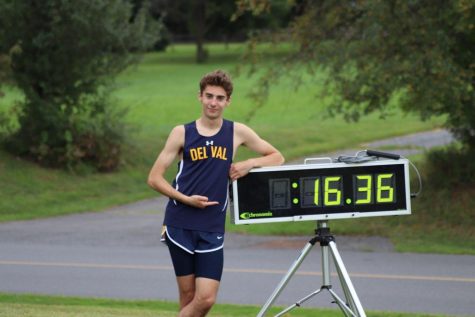 Boys Cross Country runner, Kyle Reers, stands proud next to his record breaking time.