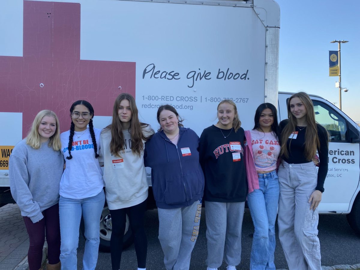 National Honors Society volunteers stand with the American Red Cross transportation vehicle.