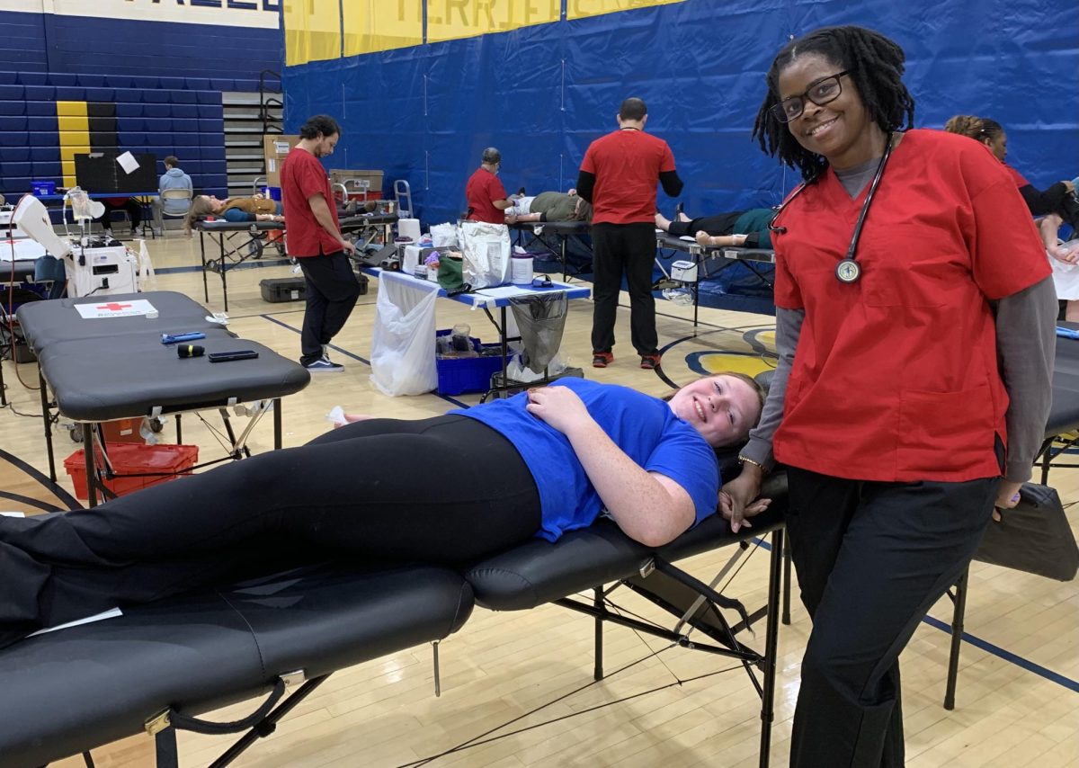 Del Val senior, Mackenzie Hlasney, smiles as she donates blood with the help of her phlebotomists.