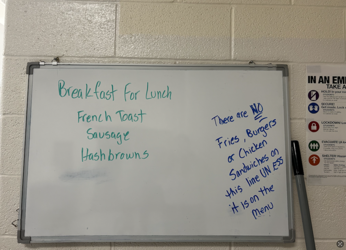 The cafeteria whiteboard explaining that hot lunch is no longer available in its original line.