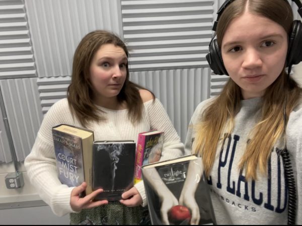 Book Yappers podcast hosts Ellie and Ella holding banned book examples.