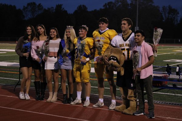 The senior class of 2025's Homecoming Court posing with their roses. Each nominee opens their rose at the same time, and the two with yellow roses are the winners.