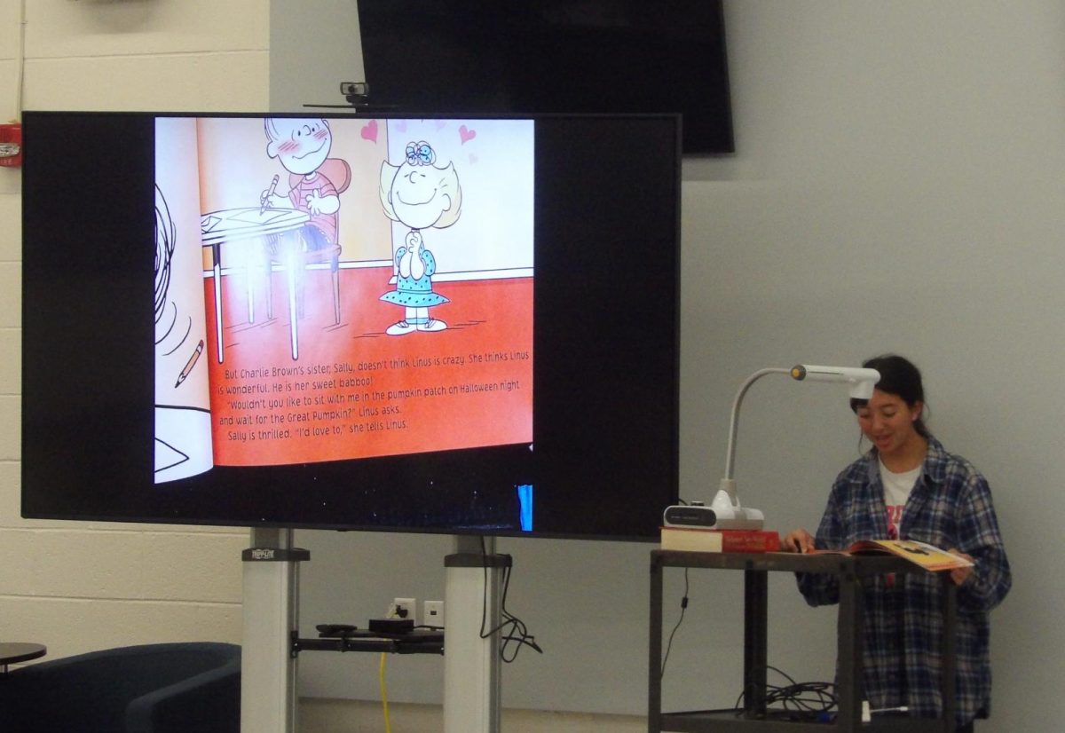 Isabella Diaz uses a page projector while reading The Great Pumpkin Charlie Brown so the kids can read along.