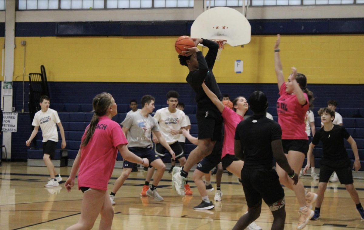 Player attempts to dunk like Michael Jordan, and is guarded by varsity basketball player, Klaudia Burke.
