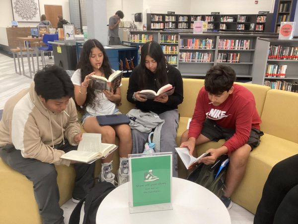 Students come together to read books from the new Spanish collection in the Commons.