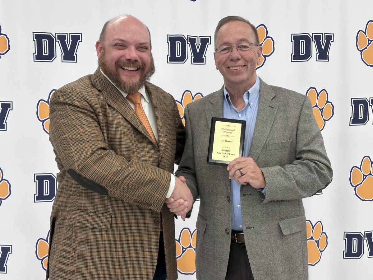 Jay Durner stands with his Arts Hall of Fame plaque alongside Kyle Tinnes. Durner was nominated along with Eugene Giancamilli for their excellence in musical education. They worked together for over 25 years. Durner, alongside Giancamilli, built the Del Val music program as the marching band and musical directors.
