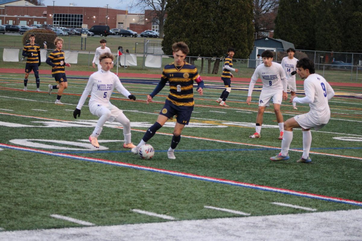 Captain Jake Cooke works his way through the Middlesex defense. His two goals were instrumental in securing Del Val's sectional title.