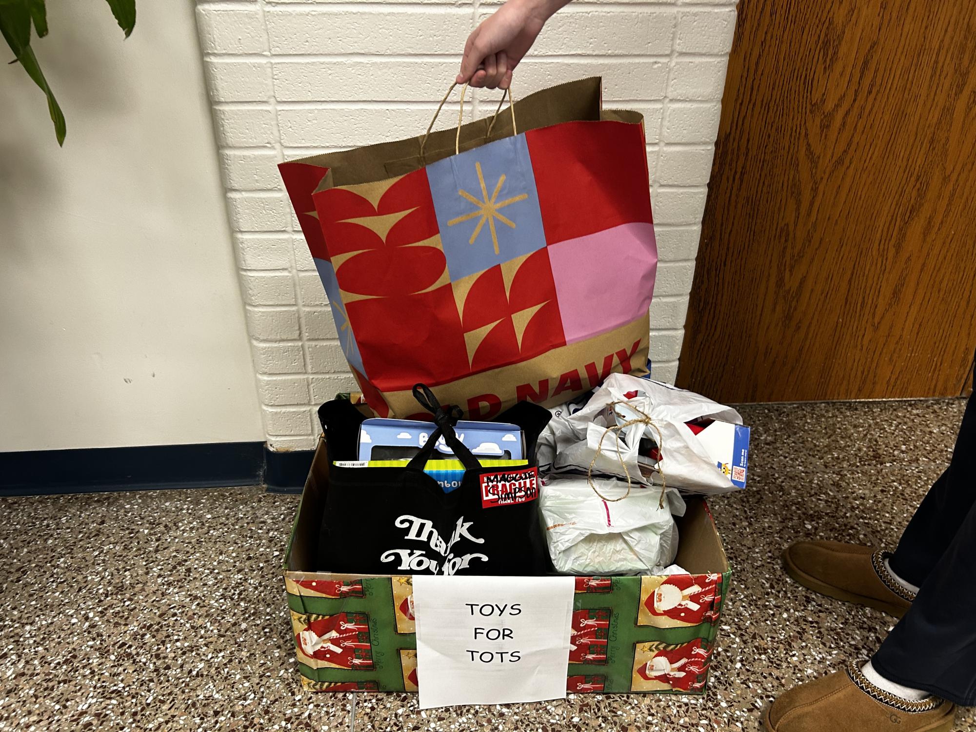There are four Toys for Tots boxes wrapped in colorful wrapping paper. Anyone looking to donate can find any of the four boxes throughout the school.