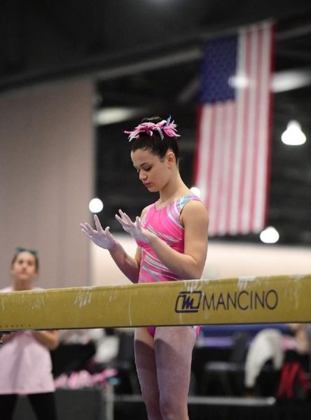 Lillyana DeMartino focuses moments before she competes in a balance beam event. (Photo via John Cheng) 
