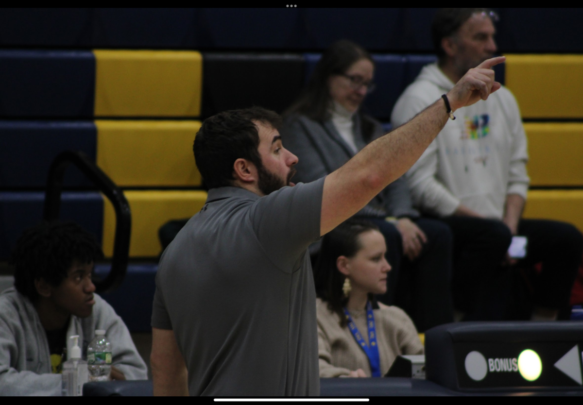 Coach Depaolo is seen giving encouragement to the basketball players. His determined mindset helped the players do their best.