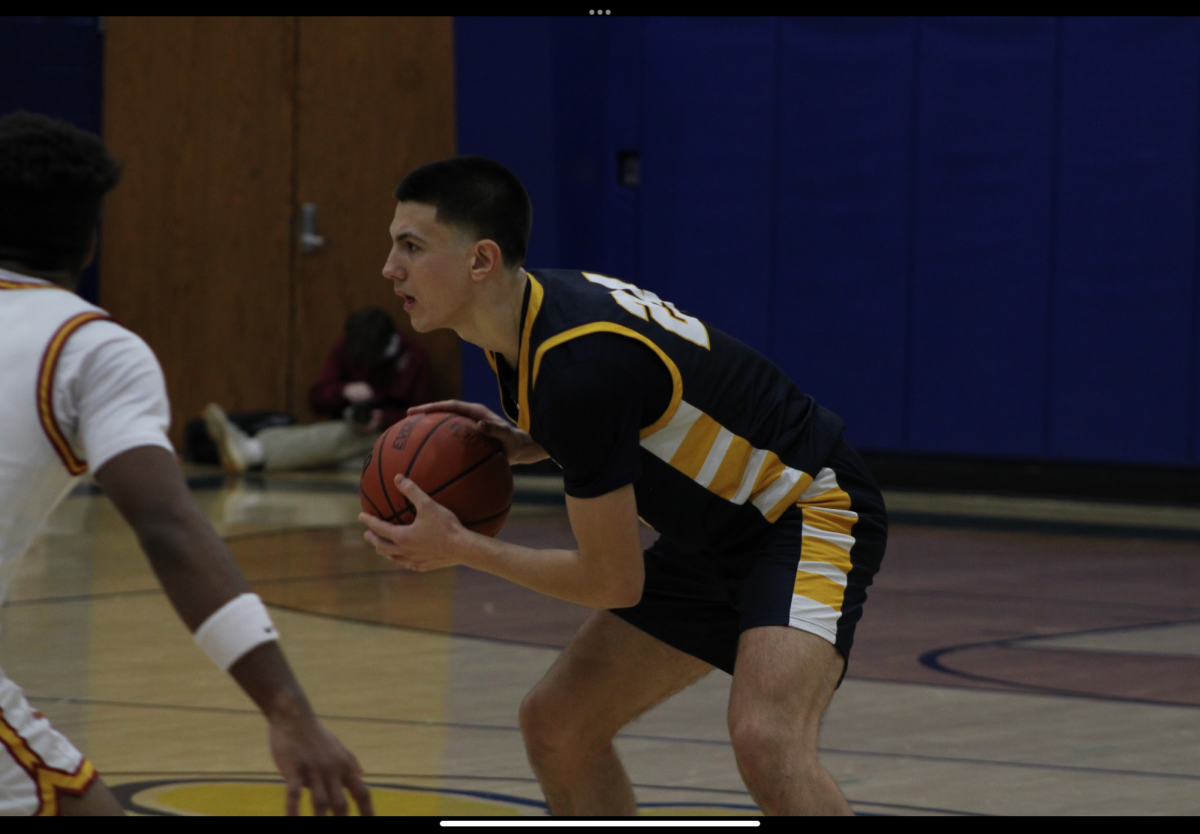 Varsity basketball player Peter Dubljevic in possession of the ball on the court. Peter was a player for youth night. 
