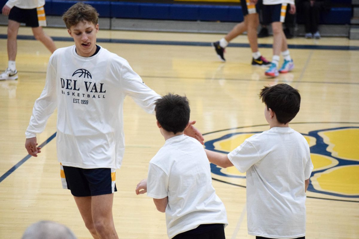 Star player Lochlyn Marsh high fives youth player prior to the game. Youth Night works to highlight the future of Del Val's sports programs.