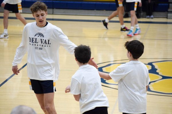 Star player Lochlyn Marsh high fives youth player prior to the game. Youth Night works to highlight the future of Del Val's sports programs.