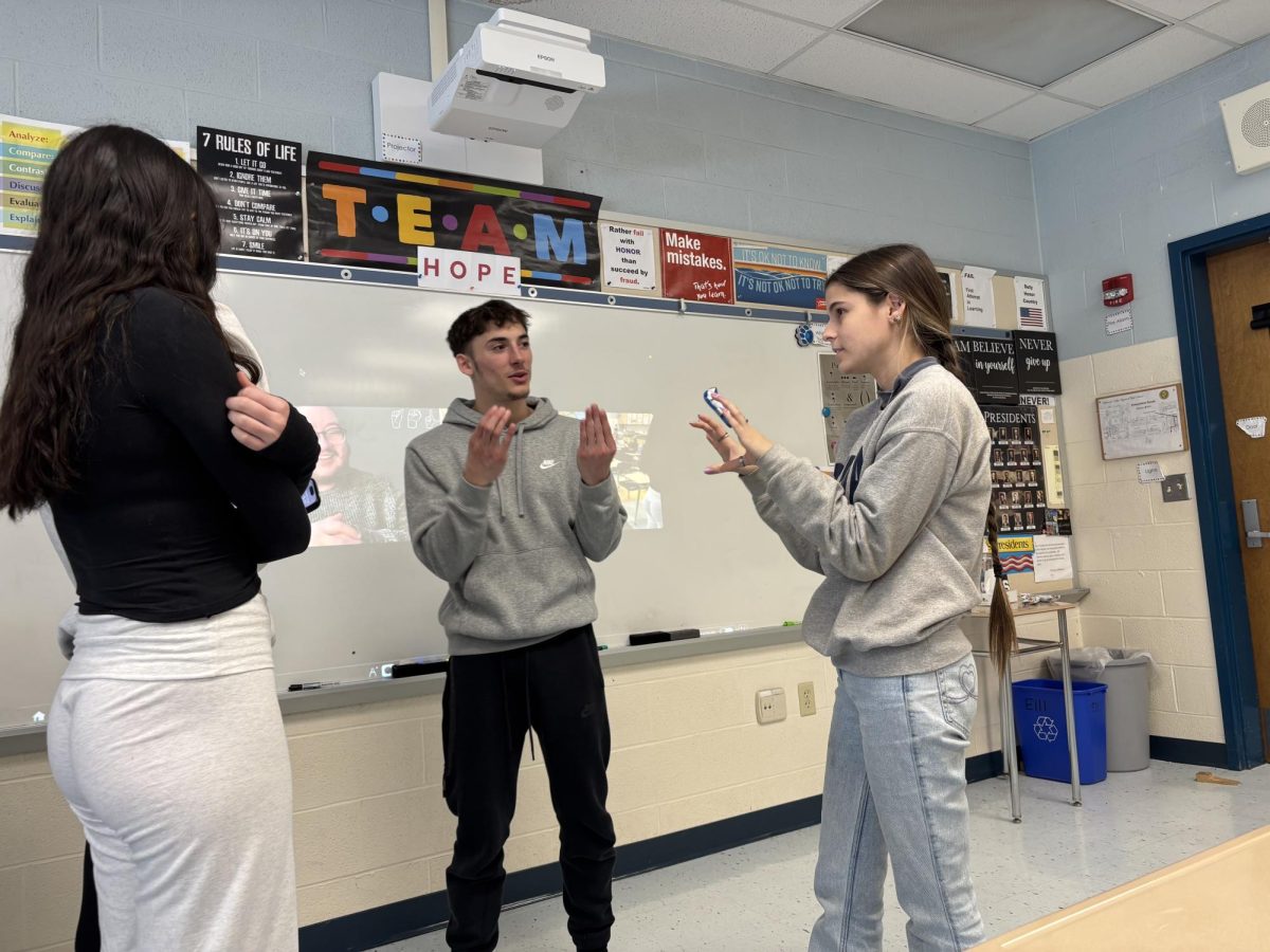 Del Val's para-professional Kaitlyn Donnelly helping Del Val senior Mossimo Pecchia learn the sign for world. Donnelly is currently in the teacher in the room for the remaining two ASL classes which are taught over Zoom.