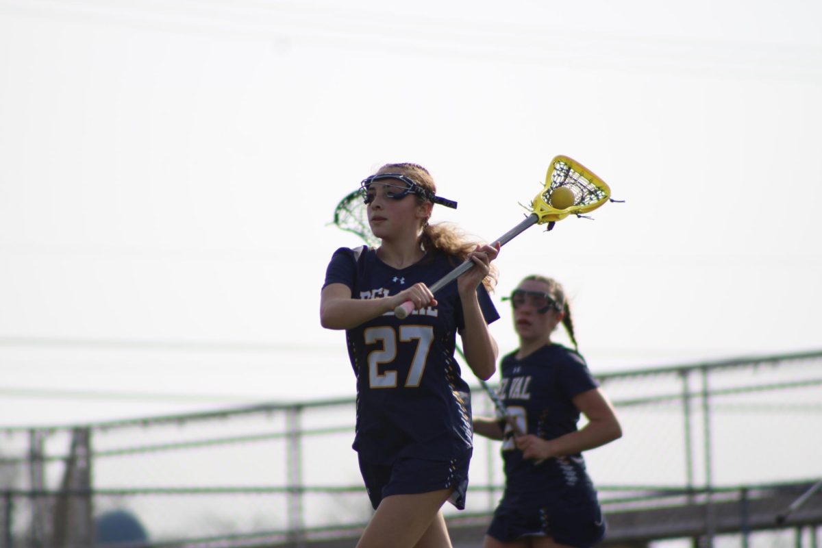 Sophomore Lacey Theesfeld holding the lacrosse ball about to pass it. Theesfeld played in the game against Somerville on March 31 where the Terriers won 14-12.