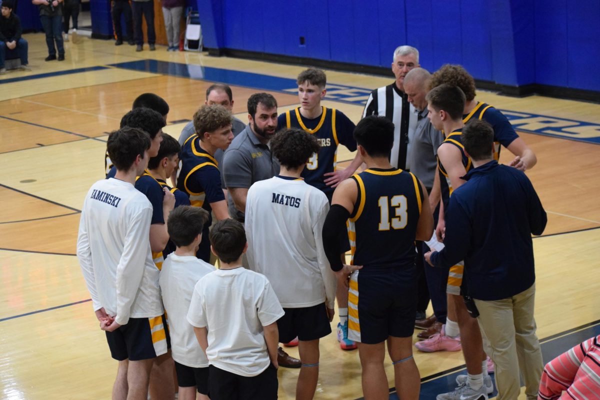 Coach Michael DePaolo rallies his team before the start of the second half. The boys varsity basketball team went on to win the Hunterdon Warren Sussex tournament.