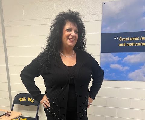 Ms. Val posing for a student, teaching them a confident pose before walking the runway. (Photo via Val Bart)