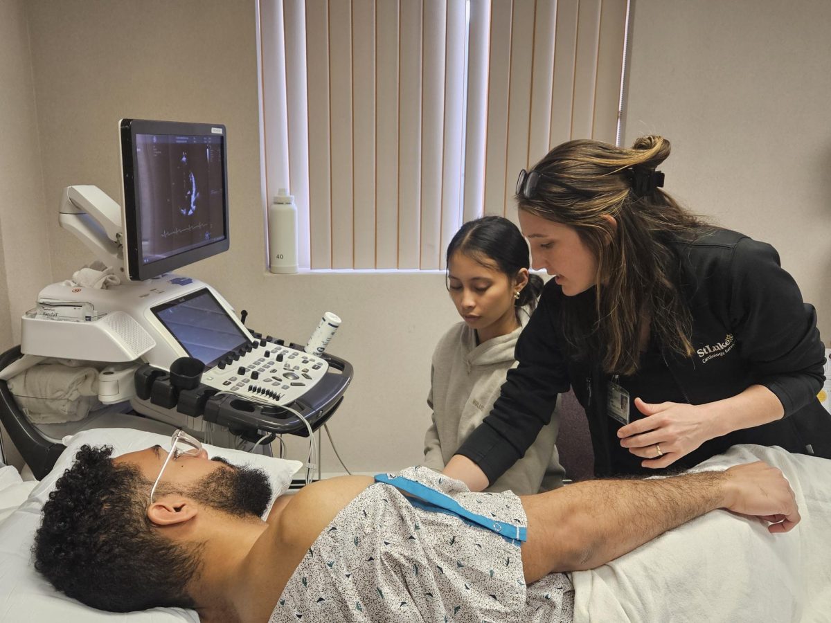 Senior Allysa Catalla practicing using Echo, a form of ultrasound technology, to look at a volunteer's heart. All students had the opportunity to use the equipment and watch up close. 