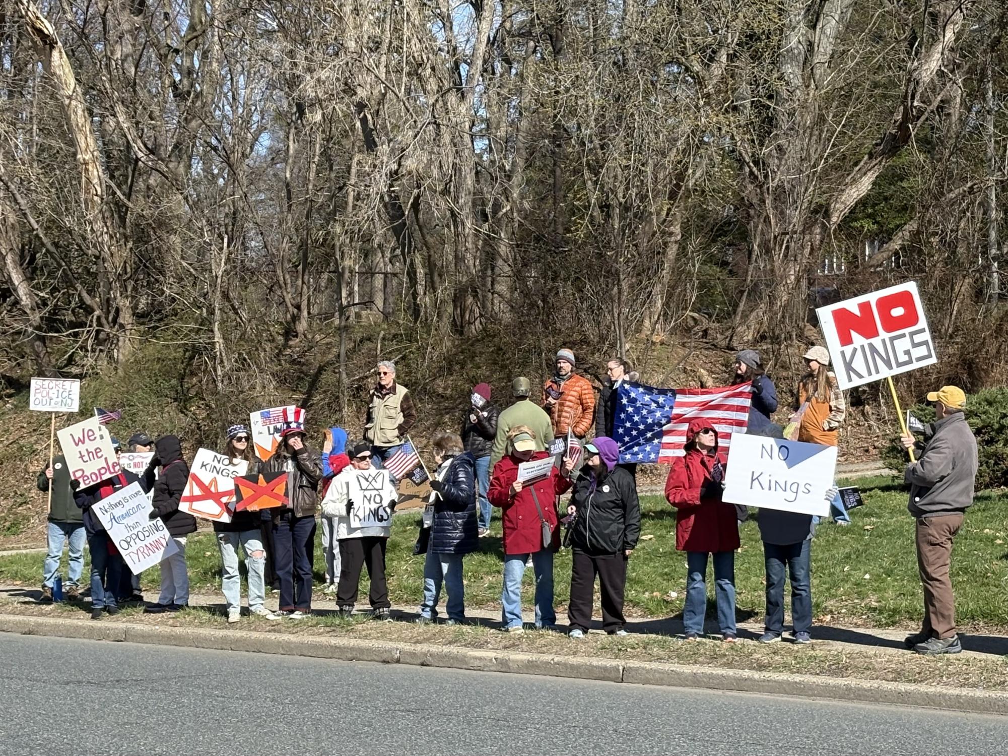 Protesters stand on Memorial Parkway in Phillipsburg to protest No Kings. Protesters stood on the edge of the parkway chanting and holding signs towards cars passing nearby.