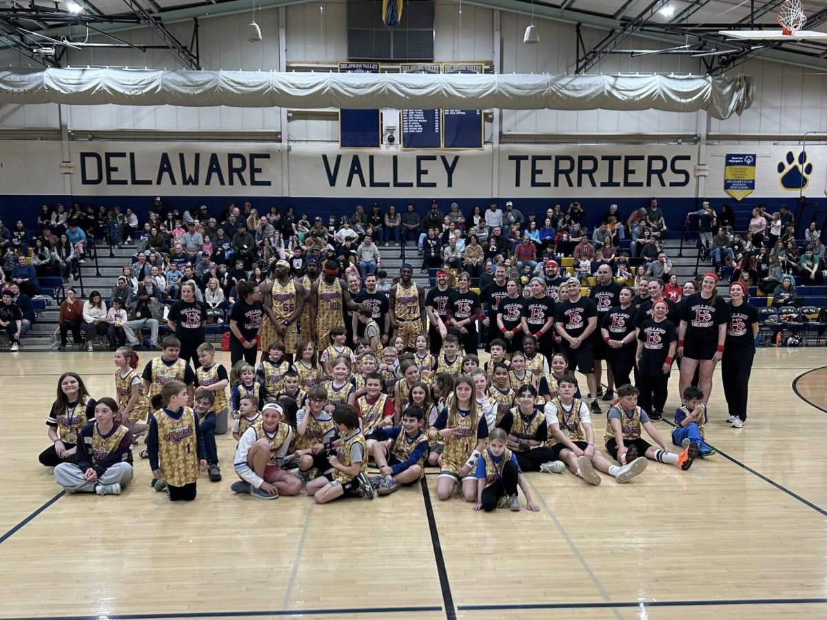 The Holland Township PTO, along with staff and students, stands for a picture with The Harlem Wizards in the Hutch Gym. The game was organized by the the PTO as a fundraiser. (Photo via Brittany Nailos)