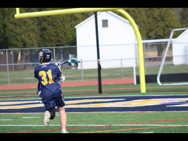 Junior Cole Fritsche cradles the ball as he gets ready to pass it. Cole got his 100th career goal a little while later during the boys lacrosse senior night.