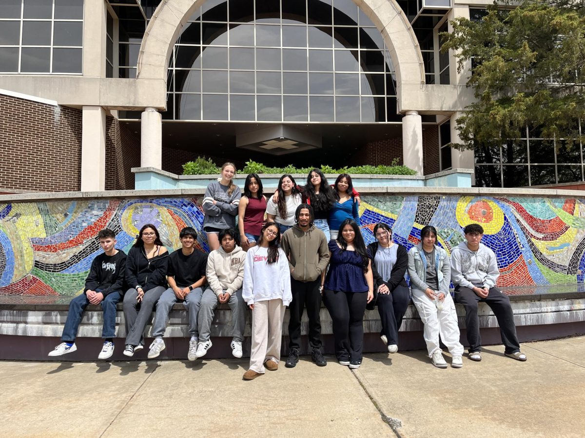 International Club students pose in front of a stone mural at one of the RVCC entrances. The trip took place on April 29. (Photo via Debra Billmann)