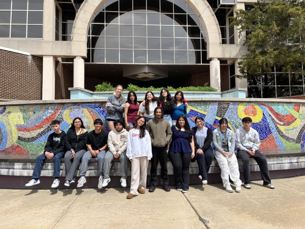 International Club students pose in front of a stone mural at one of the RVCC entrances. The trip took place on April 29. (Photo via Debra Billmann)