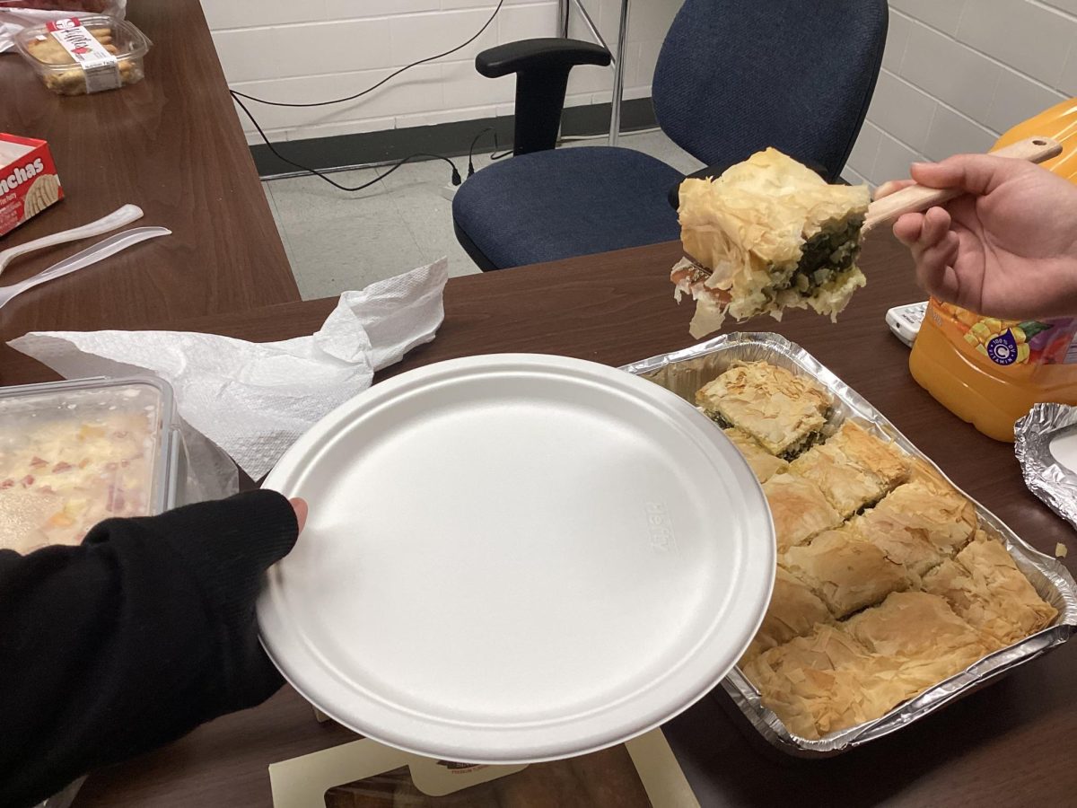 International Club member serves a traditional Greece pie, spanakopita. The dish was a favorite among the members.