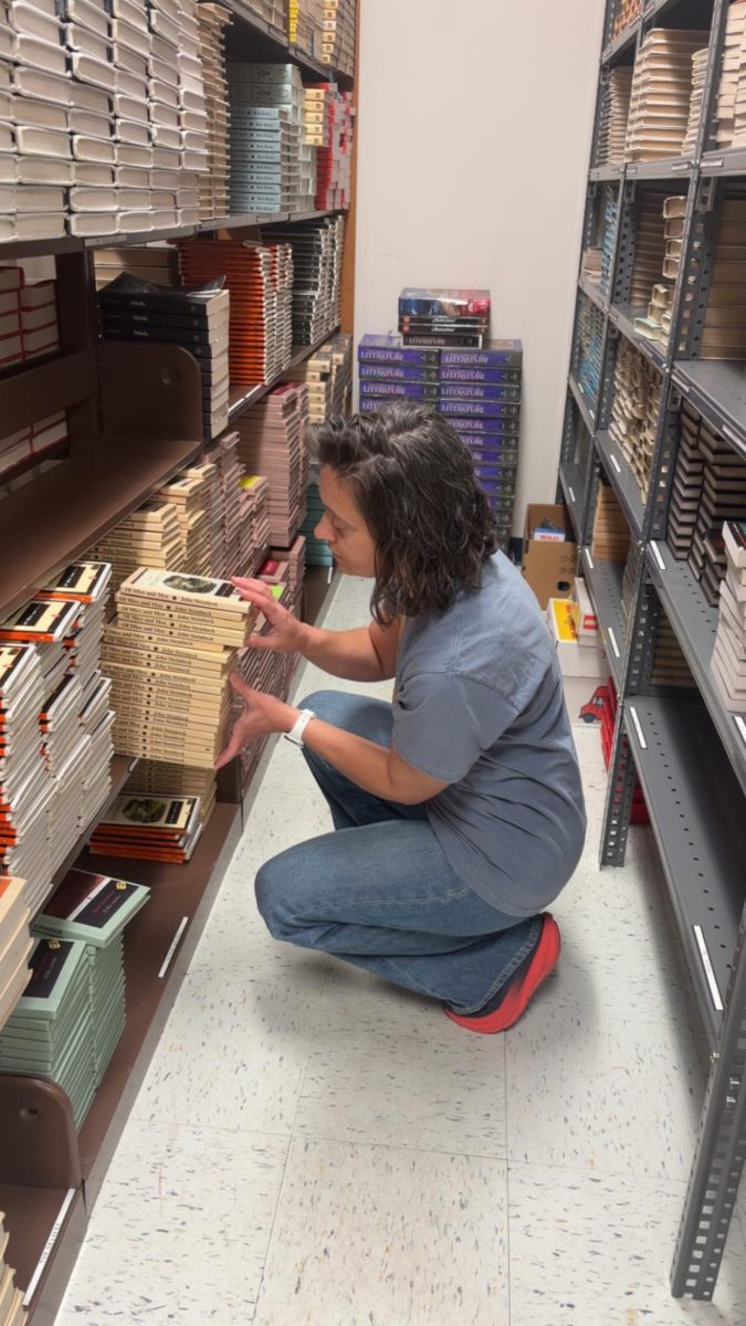 Media Specialist Tracy Miceli organizing books for English classes. For the past 19 years, at the end of each school year she has placed all english class books in the back of her office.