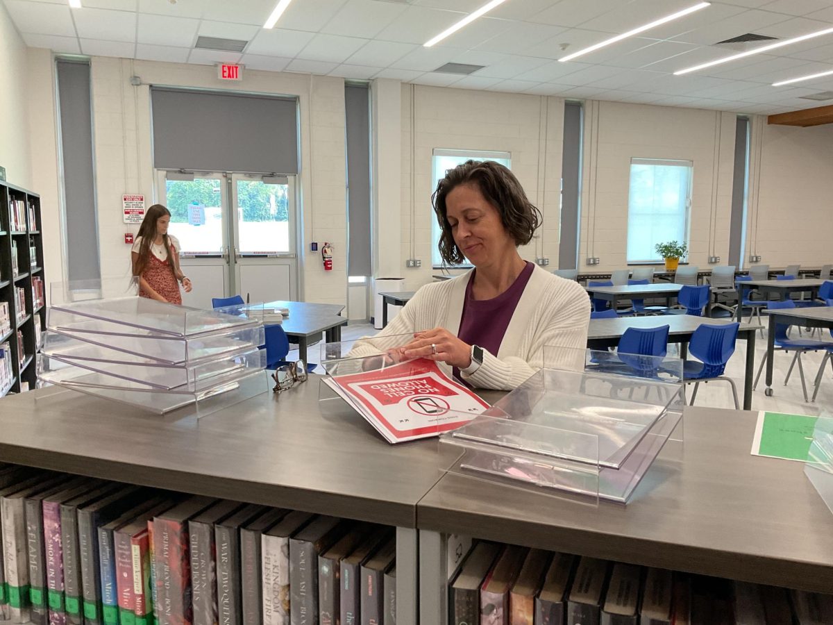 Media Specialist Tracy Miceli prepares nameplates for the bookshelves in The Commons. 