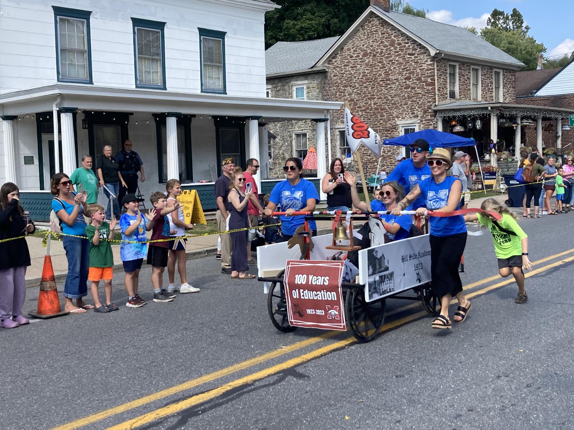 The Milford Public School races a bed down Bridge Street during Milford Alive! for the school's centennial in 2023.