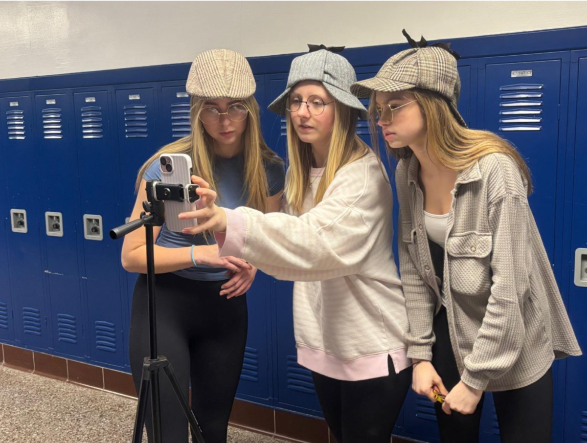 Student journalists Margot Husson, Emma Haig and Julia Hirsch use their personal cellphone to film their TikTok series, "The Delphi Detectives," during class. The segment has switched to being recorded on an iPad after the new policy was put into place.