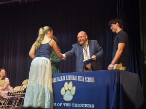 Junior Naomi Cantilina shakes Kyle Tinnes's hand, the advisor of the Tri-M Music Honors Society. Cantilina was one of almost 60 students who were inducted into Del Val's four honor societies that night.