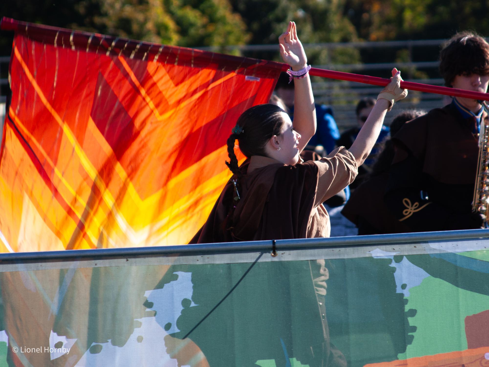 Color guard captain Kelly Torley runs with a flag during a performance at Ridge High School. The color guard act as visual storytellers in the show.