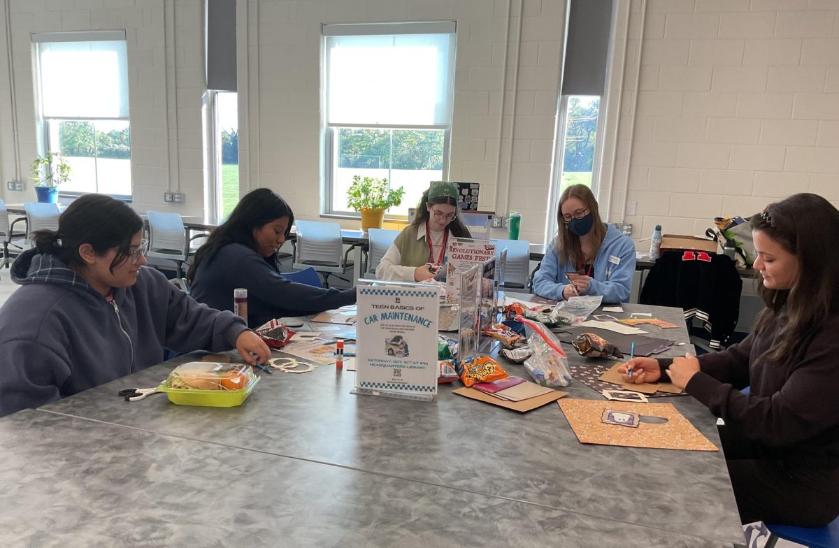 Students make a halloween craft out of recycled book pages during the October Chat and Chew. The students also learned about upcoming library events and volunteer opportunities.