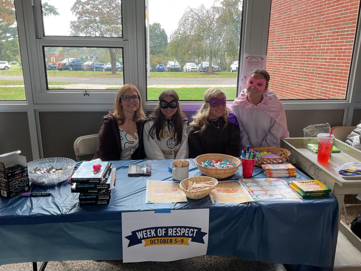 Students dress up as superheroes while helping at the table for Week of Respect. The table had markers to color the windows, hero pledges and candy for students to enjoy.