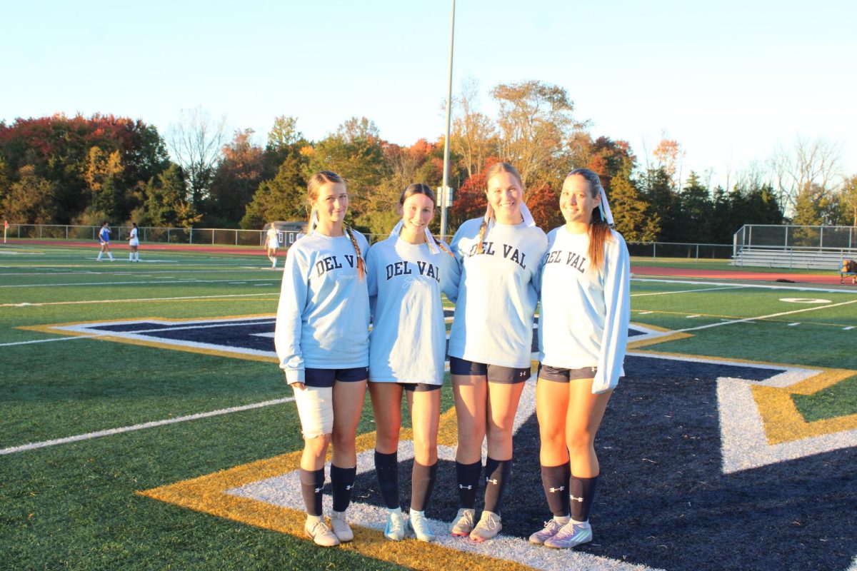All four seniors Regina Totten, Kasey Simon, Nicole Schneider and Allison Harvey stand together for a group photo before their game. 